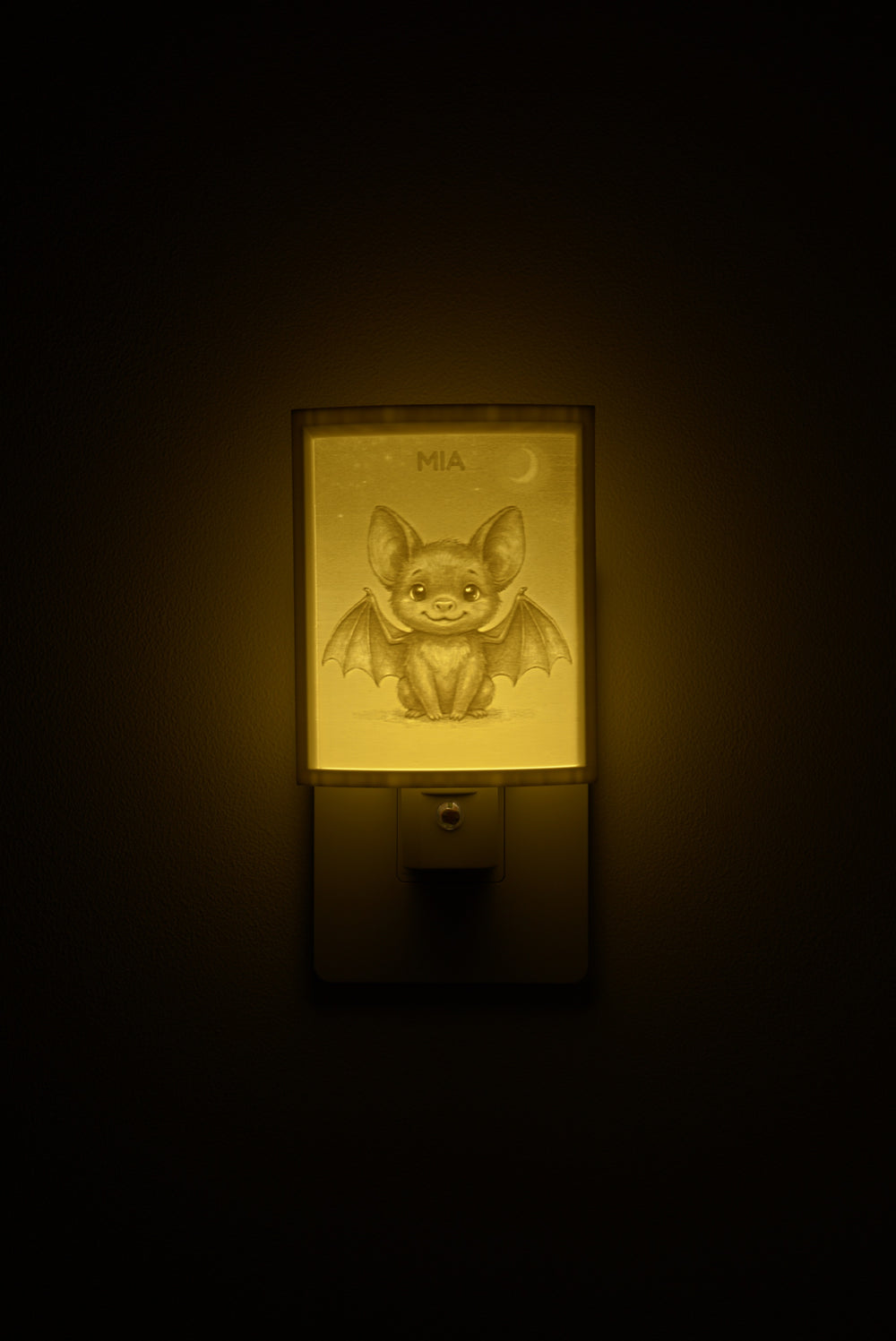 Bat night light glowing with the name MIA sculpted into the panel