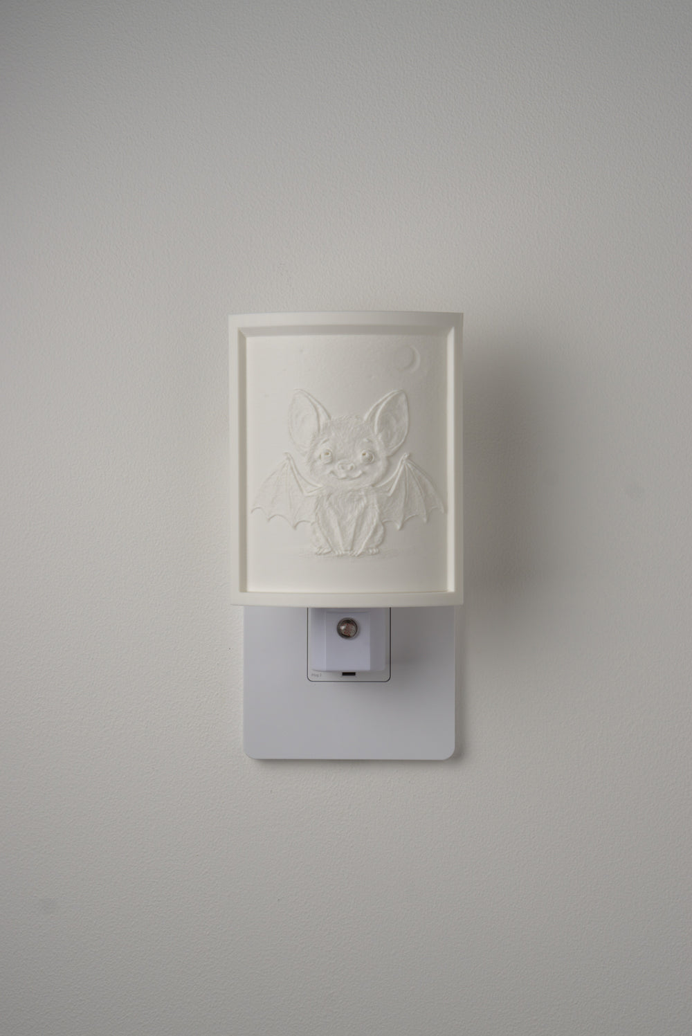 Bat night light switched off — a soft ivory panel by day