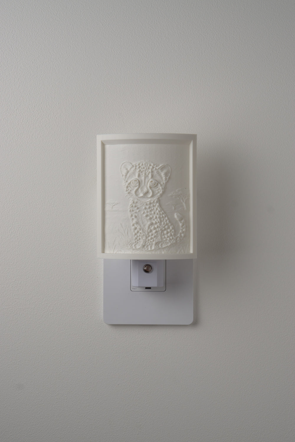 Cheetah night light switched off — a soft ivory panel by day