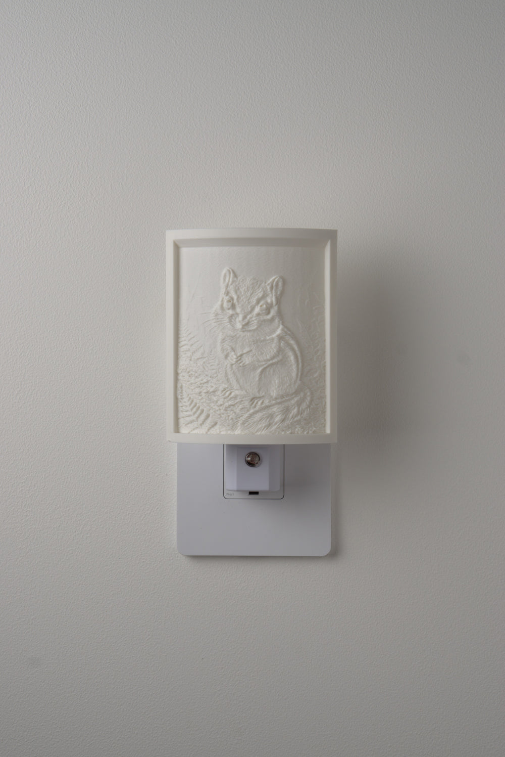 Chipmunk night light switched off — a soft ivory panel by day