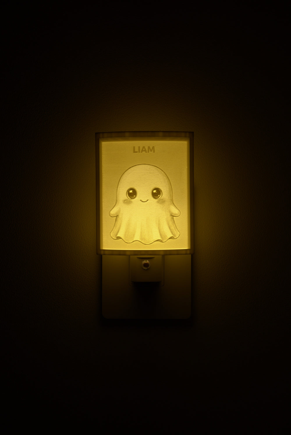 Ghost night light glowing with the name LIAM sculpted into the panel