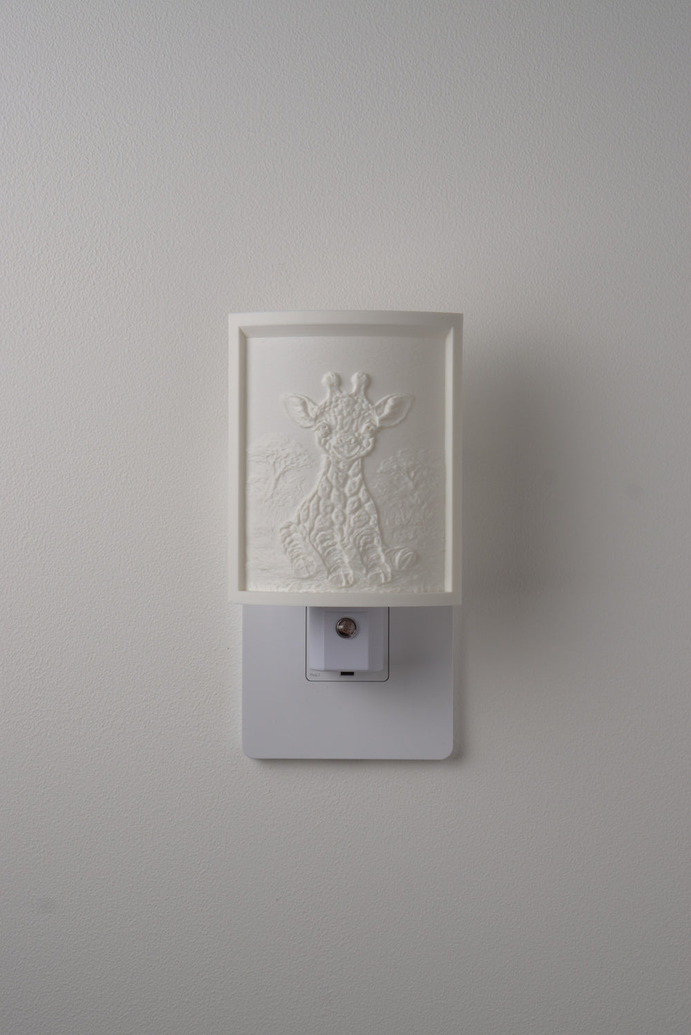 Giraffe night light switched off — a soft ivory panel by day