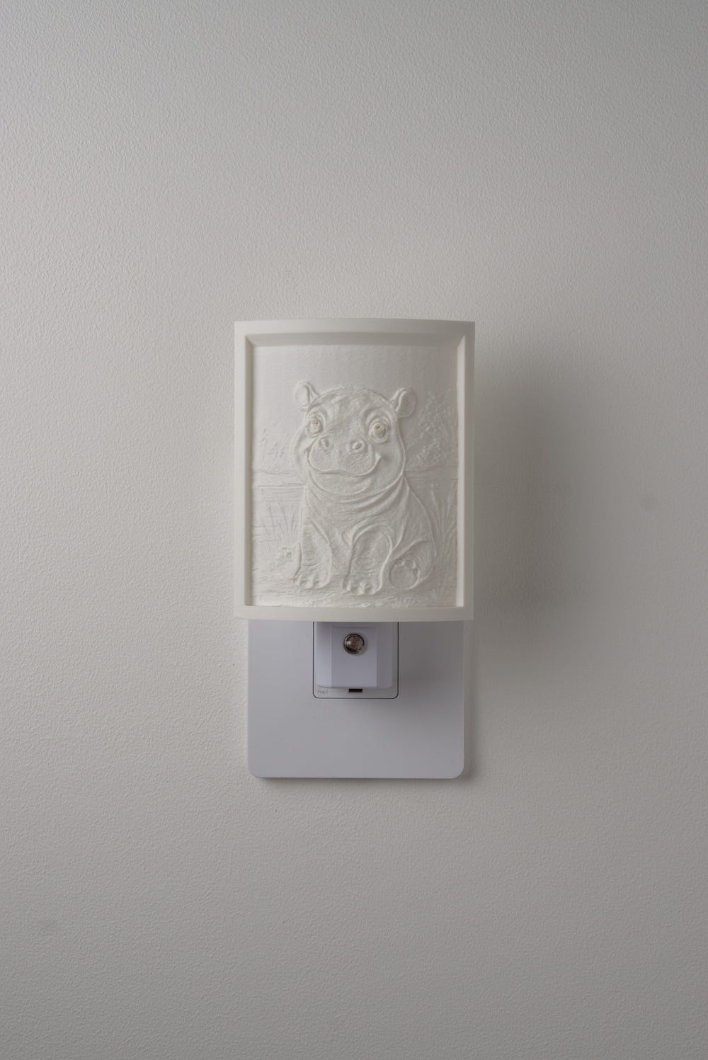 Hippo night light switched off — a soft ivory panel by day