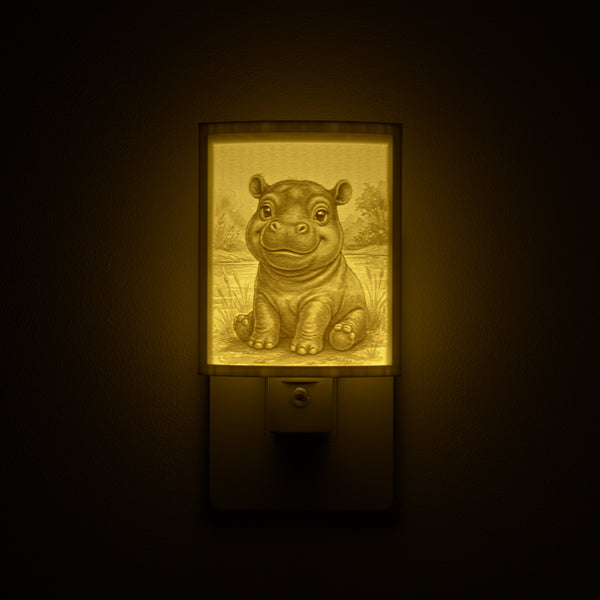 Hippo night light glowing against a dark wall, plugged into an outlet