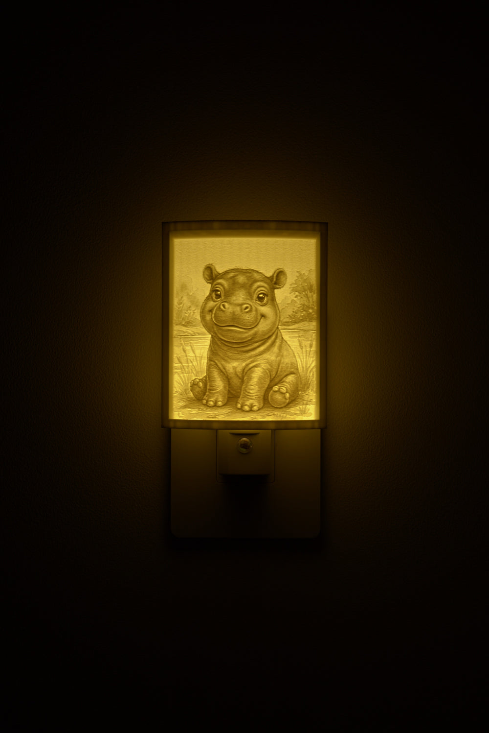 Hippo night light glowing against a dark wall, plugged into an outlet