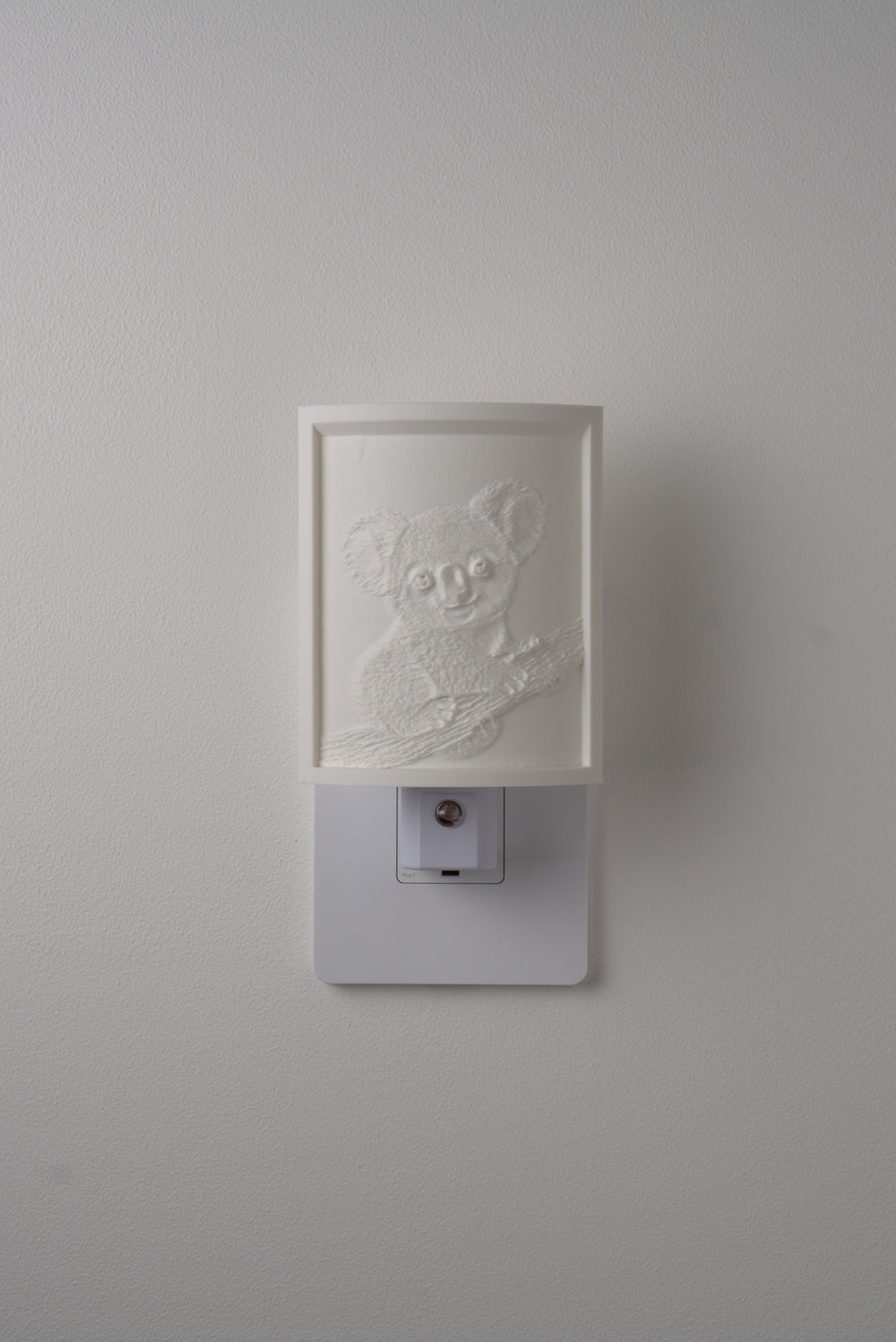 Koala night light switched off — a soft ivory panel by day