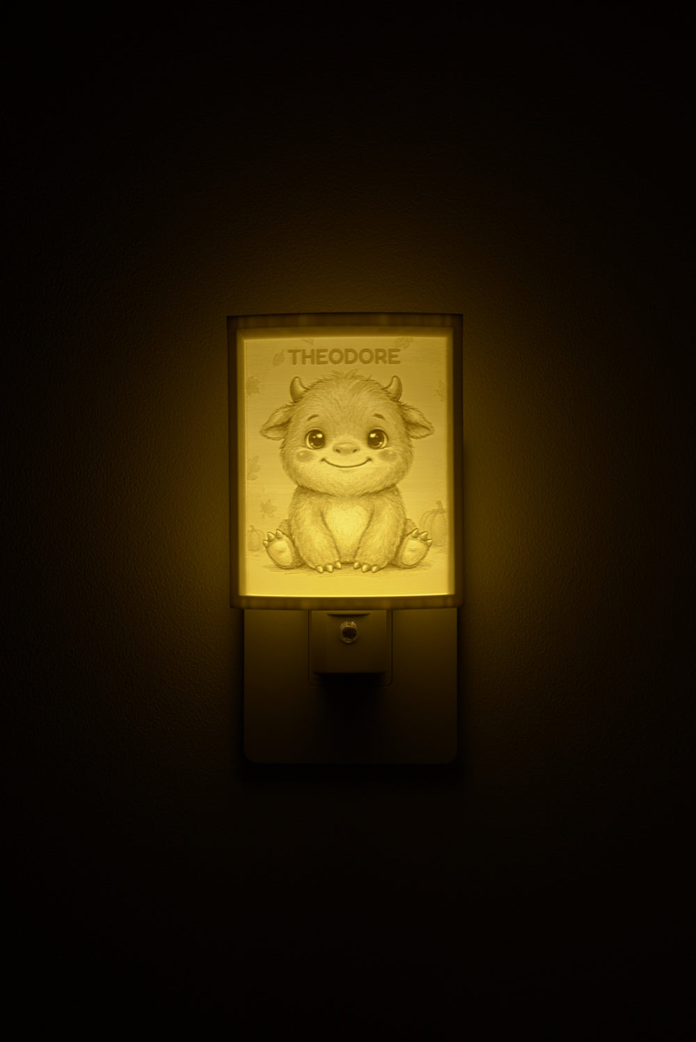 Little Monster night light glowing with the name THEODORE sculpted into the panel