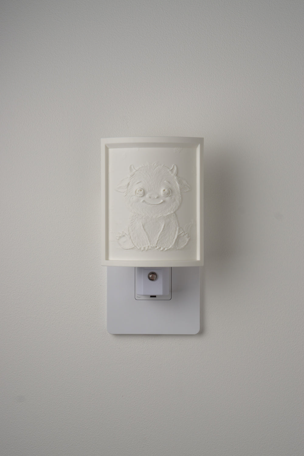 Little Monster night light switched off — a soft ivory panel by day