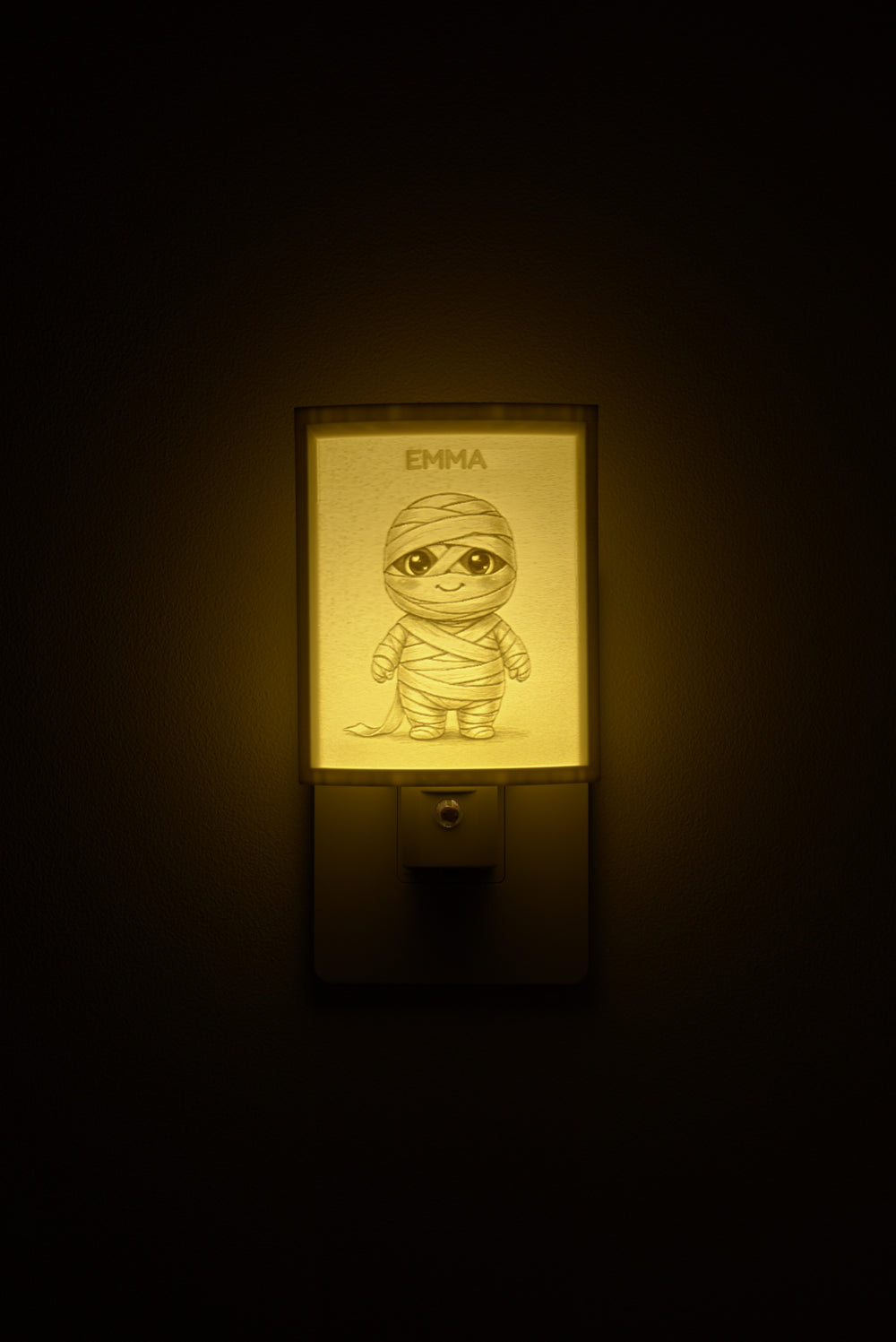 Mummy night light glowing with the name EMMA sculpted into the panel