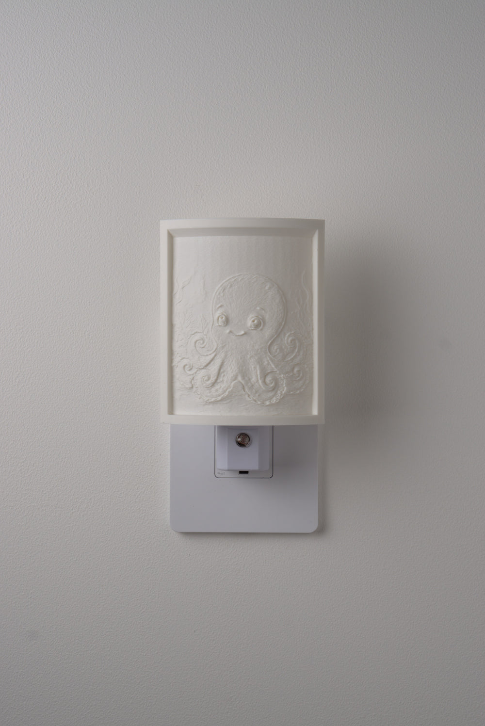 Octopus night light switched off — a soft ivory panel by day