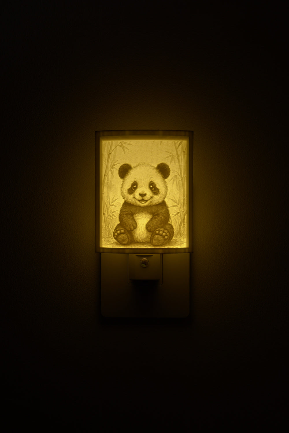 Panda night light glowing against a dark wall, plugged into an outlet