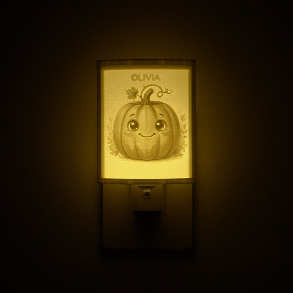Pumpkin night light glowing with the name OLIVIA sculpted into the panel