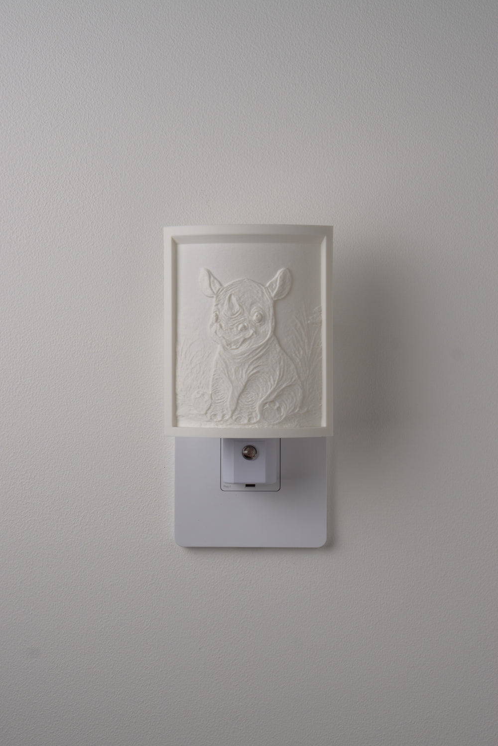 Rhino night light switched off — a soft ivory panel by day