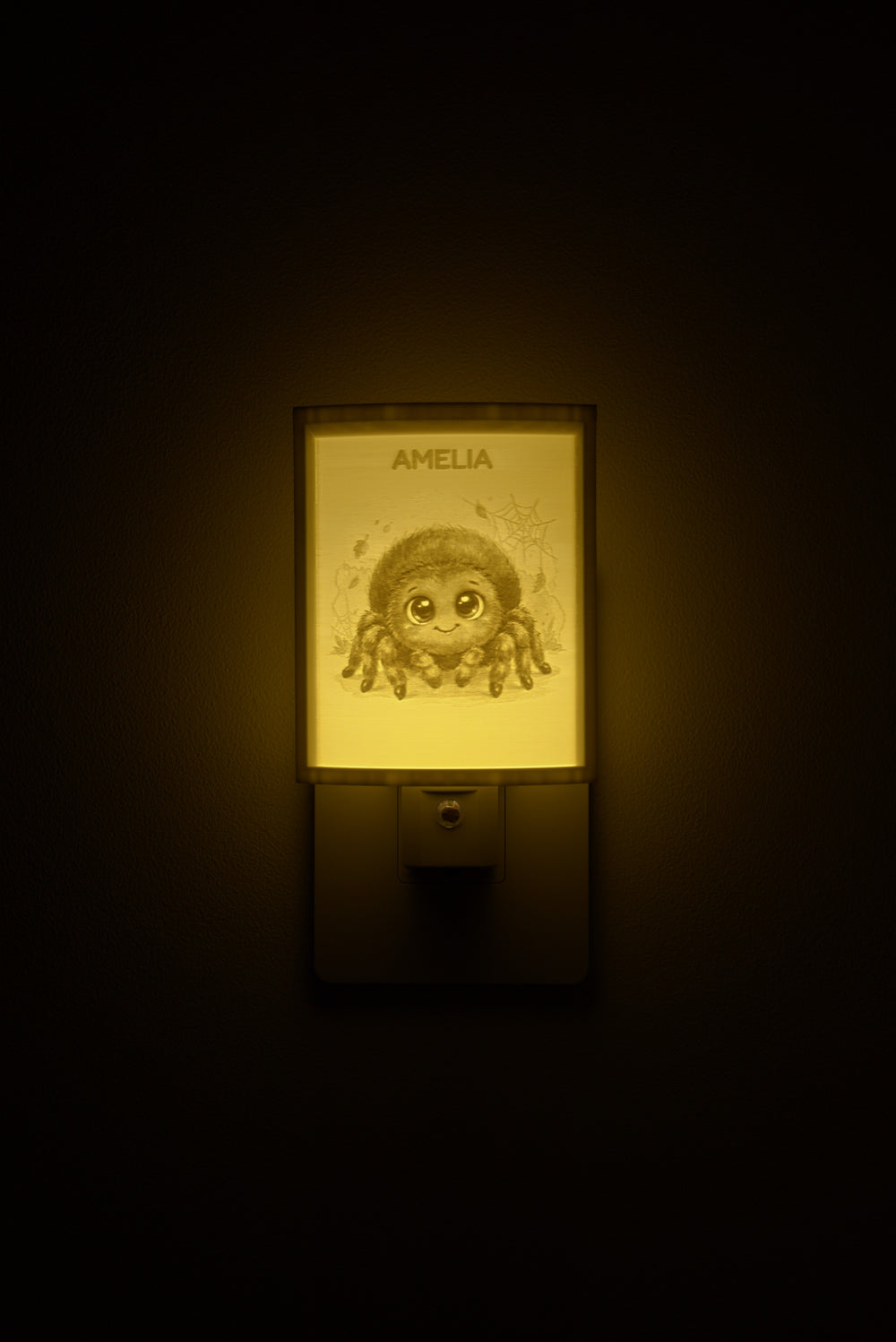 Spider night light glowing with the name AMELIA sculpted into the panel