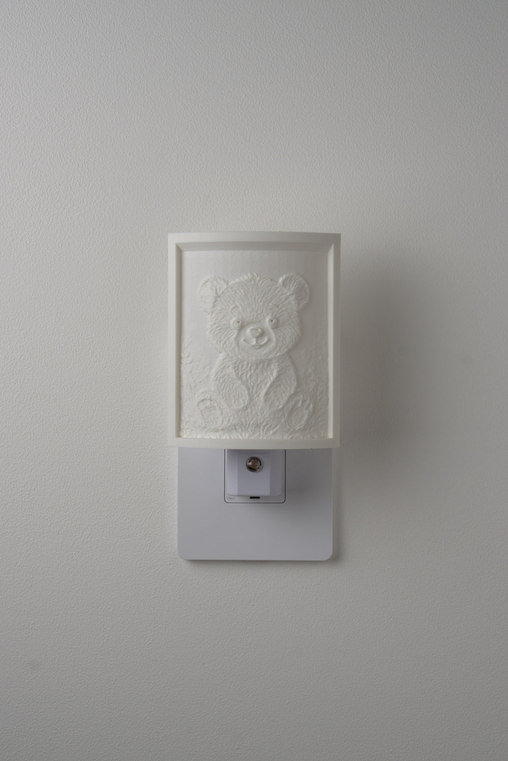 Teddy Bear night light switched off — a soft ivory panel by day