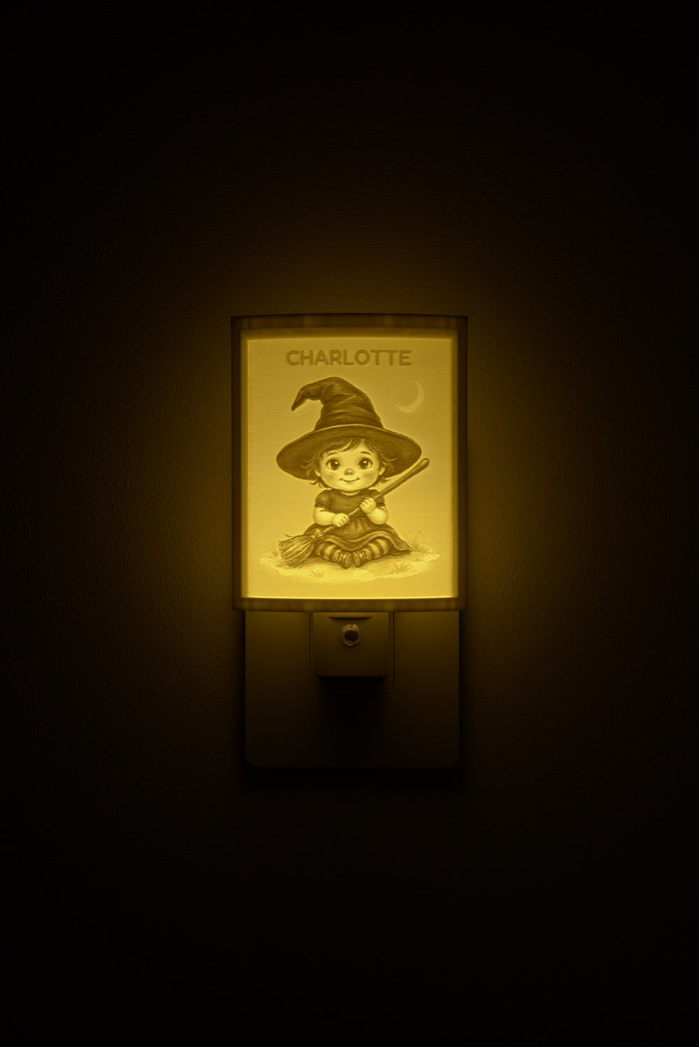 Little Witch night light glowing with the name CHARLOTTE sculpted into the panel