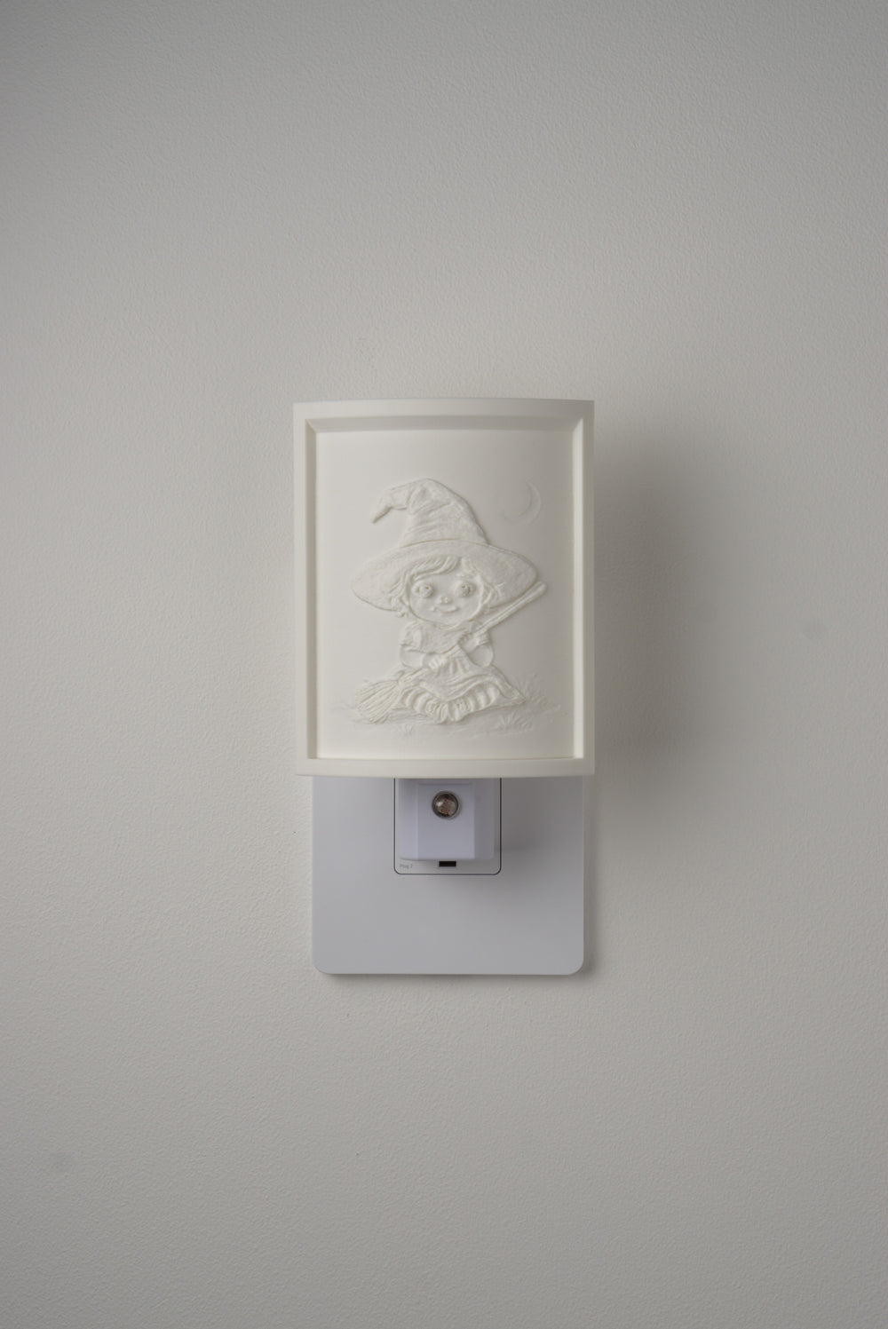 Little Witch night light switched off — a soft ivory panel by day
