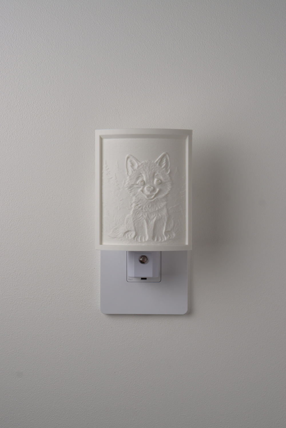 Wolf night light switched off — a soft ivory panel by day