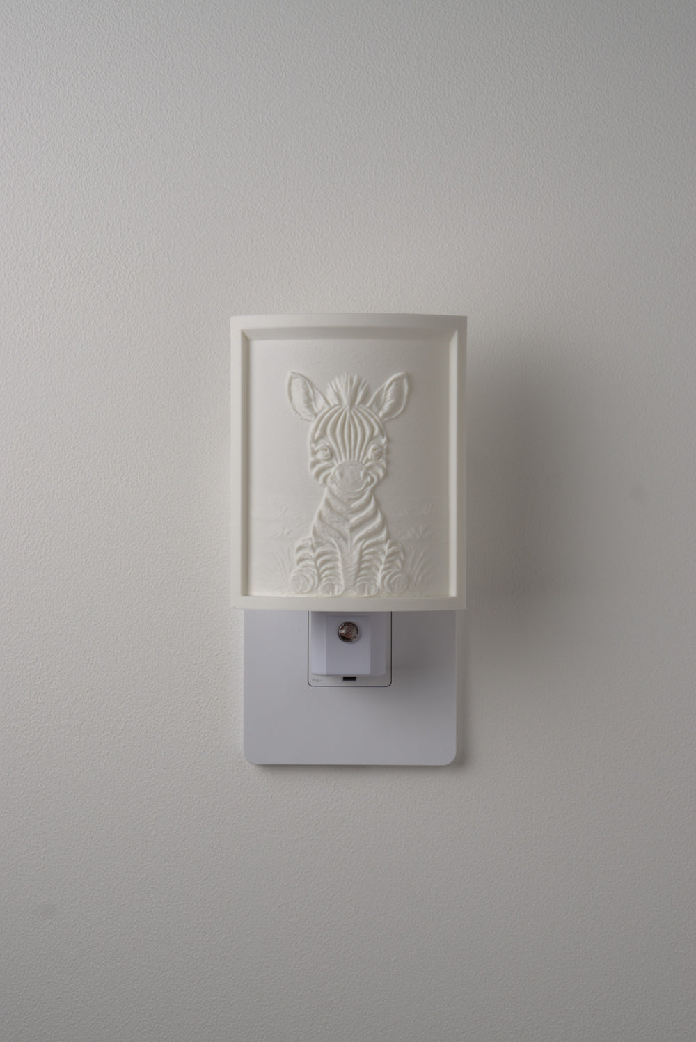Zebra night light switched off — a soft ivory panel by day
