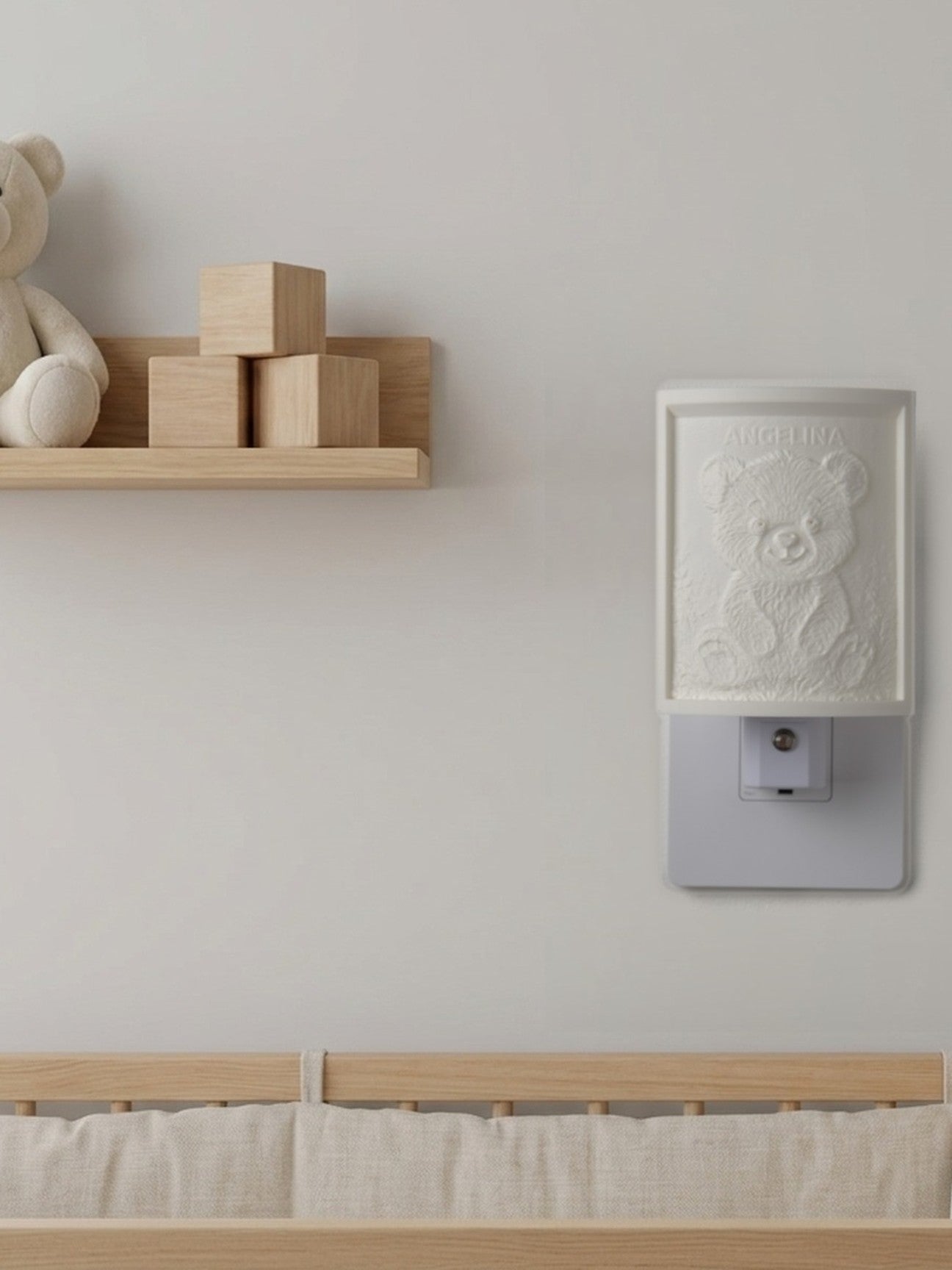 Our night light on a nursery wall by day, beside a shelf with a plush bear and wooden blocks